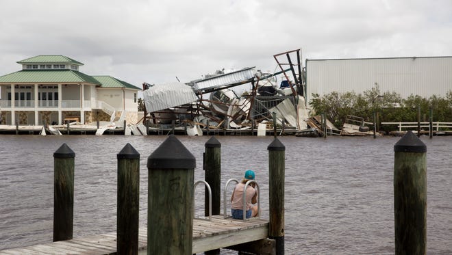 A woman looks across the channel to a demolished marina in Goodland, Fla. Monday, September 11, 2017.