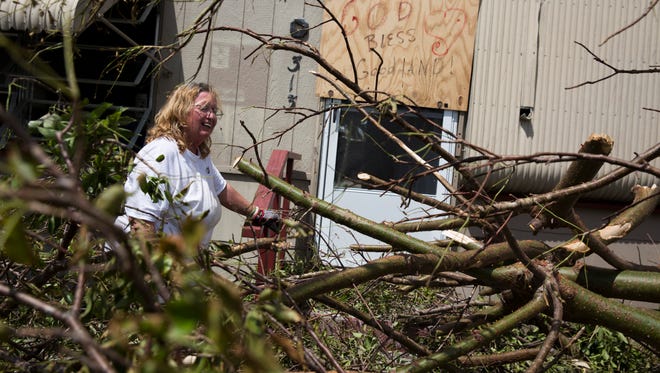 Margie Hackett slowly saws away branches that had fallen mere feet from her front door in Goodland, Fla. Monday, September 11, 2017.