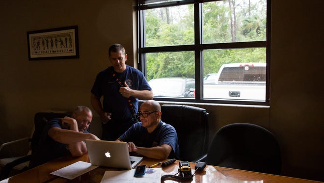 (From left to right) Thomas Easley, firefighter, Captain Jason Sellers, and Lieutenant Manny Arroyo monitor Hurricane Irma at the Greater Naples Fire Rescue Station 72 on Sunday, September 10, 2017.
