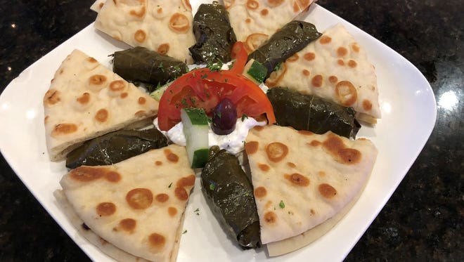 Dolmadaki, stuffed grape leaves filled with seasoned rice, served with tzatziki sauce and grilled pita bread at Olympia Dining, Naples.