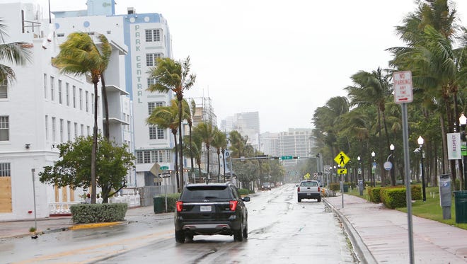 A vehicle drives down an empty Ocean Drive on South Beach as the outer bands of Hurricane Irma reached South Florida early Sept. 9, 2017 in Miami.