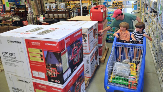 Ron Arthur and his sons Xander, 5, and Mason, 7, shop through the Lowe's Home Improvement store in Indian Harbour Beach on Friday. That generator that caught their eye is on the list of approved tax-free purchases between now and 11:59 p.m. June 8.