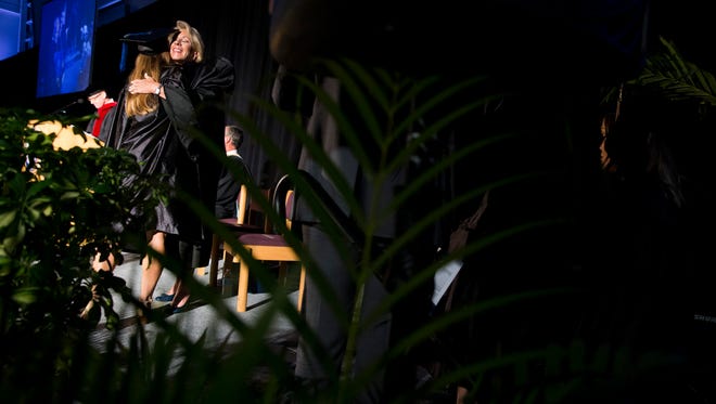 U.S. Secretary of Education Betsy DeVos greets Ave Maria University graduates as they walk across the stage to receive their diplomas at Golisano Field House Saturday, May 5, 2018 in Ave Maria. DeVos gave the commencement address during the ceremony.