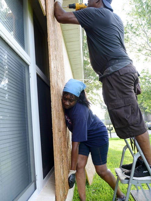 Carrie and Ron Wilcox of West Melbourne put up shutters in preparation for Hurricane Irma Friday.