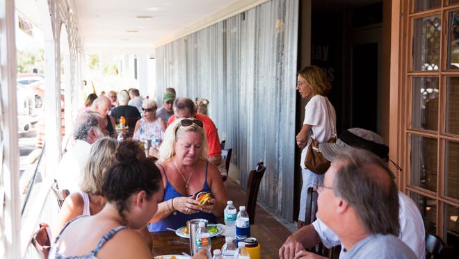 Marco Island residents sit down to eat at Kretch's on Tuesday, September 12, 2017, two days after Hurricane Irma. Kretch's and CJ's teamed up to fire up the grills to feed hot meals to those without power.