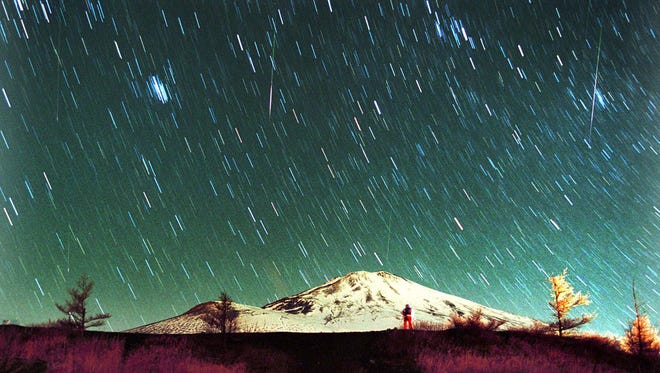 Leonid meteors are seen streaking across the sky over snow-capped Mount Fuji, Japan's highest mountain on Nov. 19, 2001, in this 7-minute exposure.