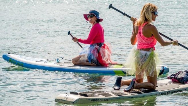 Marcella Scherer (left), of Jupiter heads out with other volunteers during the Chasin A Dream Foundation ?Trashy Tutu mangrove cleanup? near Coral Cove Park in Jupiter on Aug. 7, 2018.