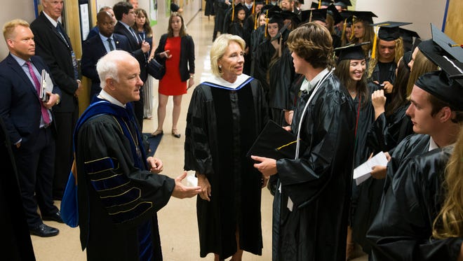 U.S. Secretary of Education Betsy DeVos greets soon to be Ave Maria University graduates with Ave Maria University President Jim Towey, left, prior to delivering her commencement address during Ave Maria's graduation ceremony at Golisano Field House Saturday, May 5, 2018 in Ave Maria.