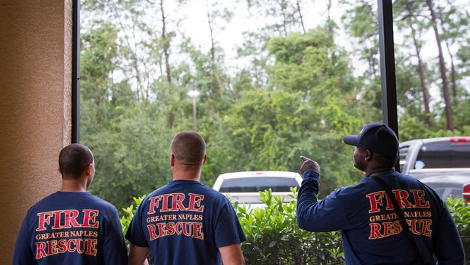 From left to right, Aaron Douglas, Aaron Odum and Torrence Andrews stand on the lanai at the Greater Naples Fire Rescue Station 72 and watch as winds start to pick up on Sunday, September 10, 2017 as Hurricane Irma comes closer to Naples.