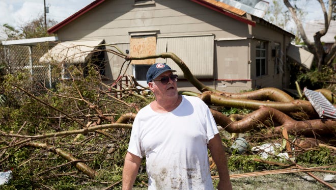 John Hackett stands in front of his home and the downed tree that nearly crushed it in Goodland, Fla. Monday, September 11, 2017.
