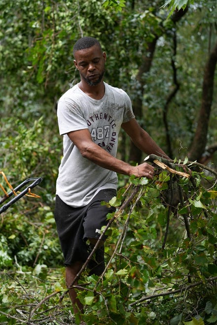 Antonio Green helps clear fallen trees from a home in Perry, Fla. after Hurricane Idalia hit the area on Wednesday, Aug. 30, 2023. The storm landed as a Category 3 along Florida’s Big Bend area, leaving some homes and businesses destroyed.