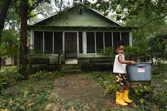 Harmony Green helps her family move debris from a neighbor's yard in Perry, Fla. after Hurricane Idalia hit Florida on Aug. 30, 2023.