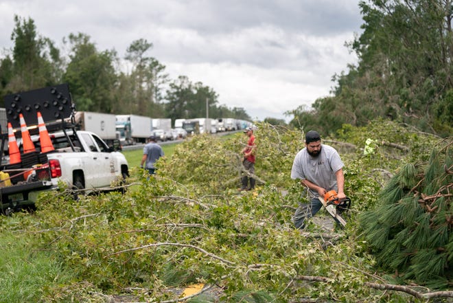 People work to clear I-10 of fallen trees after Hurricane Idalia crossed the state on Aug. 30, 2023 near Madison, Fla.