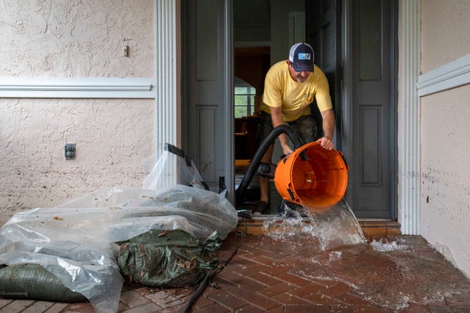 David Norrie dumps a bucket of water he vacuumed up while cleaning up his home after Hurricane Idalia in Crystal River, Fla. on Aug. 31, 2023. The home is unlivable after the flooding damages the floors, drywall and carpet.