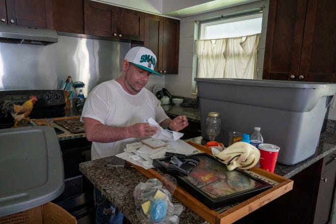 Michael Gonzalez sorts through personal items after flooding from Hurricane Idalia ruined his aparmtnet and most of his things in Crystal River, Fla. on Aug. 31, 2023.