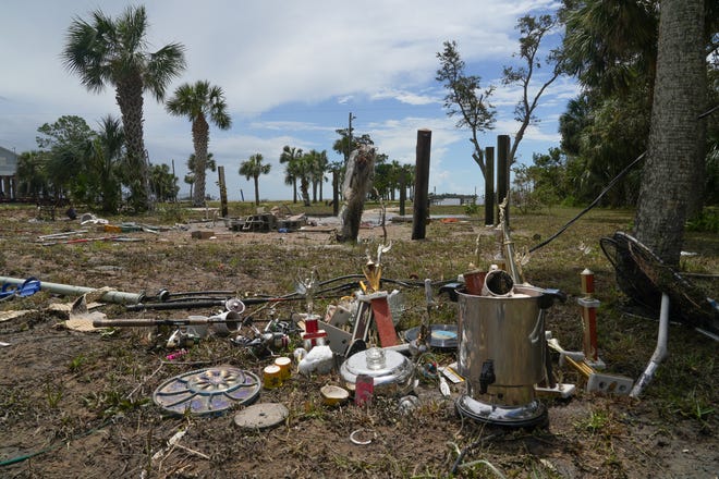 Trophies, vinyl records and home supplies are gathered in a plot of land where a home used to be in Horseshoe Beach on Aug. 31, 2023. Hurricane Idalia made landfall on the Gulf Coast of Florida. The Category 3 storm made landfall Wednesday leaving some homes and businesses destroyed.