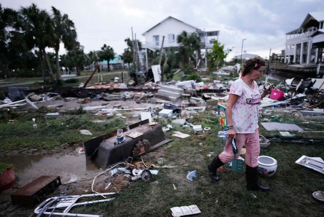 Jewell Baggett walks amidst debris strewn across the yard where her mother's home had stood as she searches for anything salvageable in Horseshoe Beach, Fla., after the passage of Hurricane Idalia, Wednesday, Aug. 30, 2023.