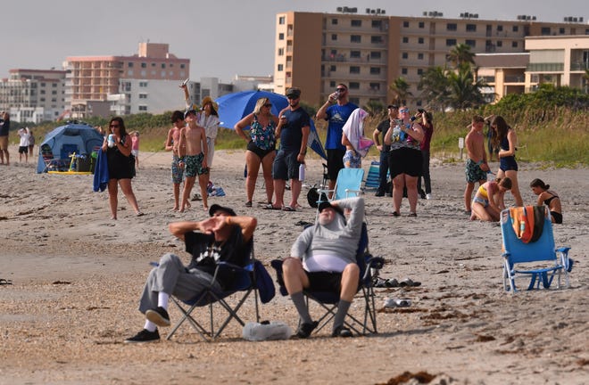 People in Cape Canaveral watch the launch of a SpaceX Falcon Heavy for NASA 
 from Launch Pad 39A at Kennedy Space Center, launched at 10:19 a.m. EDT October 13th with boosters landing at Landing Zones 1 and 2 at Cape Canaveral Space Force Station.
