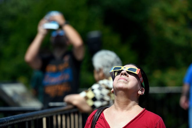 Linda Gorman-Bellome of Paterson peers at the solar eclipse while at the Great Falls in Paterson, NJ on Monday, August 21, 2017.