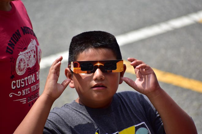 Jesus Coyotl, putting on glasses. Eclipse as viewed in front of the Boonton Library on Monday afternoon August 21, 2017.