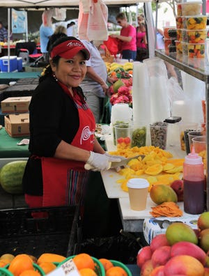 A woman cuts mangoes at Marco Island Farmers' Market.