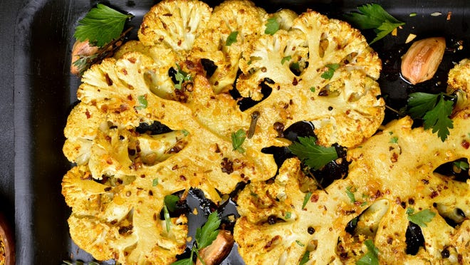 Turmeric-roasted cauliflower (directions) • Total time: 1 hour 20 minutes Preheat oven to 425 ° F. In a small bowl, combine the oil, cumin, turmeric, crushed red pepper and 1/2 teaspoon of salt. Divide cauliflower onto 2 large rimmed baking sheets. Drizzle the cauliflower with the spiced oil and toss well to coat; season with salt to taste. Spread the cauliflower in an even layer and bake for about 1 hour, until browned and tender; switch the position of the baking sheets halfway through cooking. Meanwhile bake the pine nuts for about 1 minute, until toasted. Let cool. Transfer the cauliflower to a large serving bowl. Sprinkle with the pine nuts, cilantro, and mint and serve. The cauliflower can be roasted and refrigerated overnight; reheat before combining with the pine nuts and herbs.