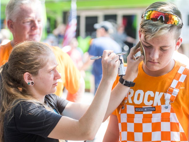 Fans get a Power T painted on their faces before the Tennessee Volunteers' game against West Virginia in the Belk College Kickoff at Bank of America Stadium in Charlotte, N.C., on Saturday, Sept. 1, 2018.