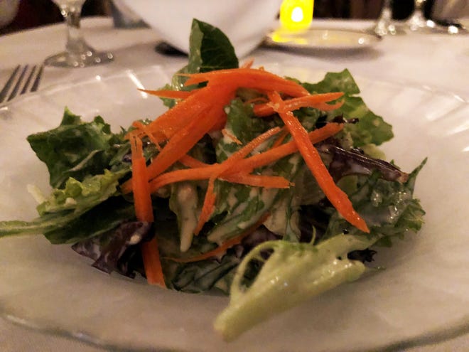 The complimentary house salad tossed in a homemade black peppercorn and garlic vinaigrette from Bistro Soleil, Marco Island.