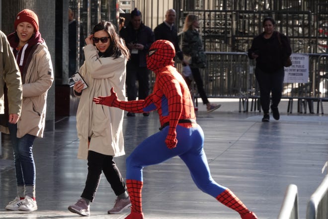 A costumed Spider-Man performer tries to stop action on Hollywood Boulevard.