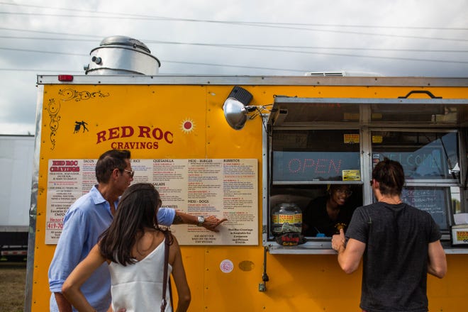 Customers order at Red Roc cravings, one of a dozen food trucks at the Naples City Live event in Naples on April 6, 2019. In recent years, the food truck business has grown exponentially in Naples.