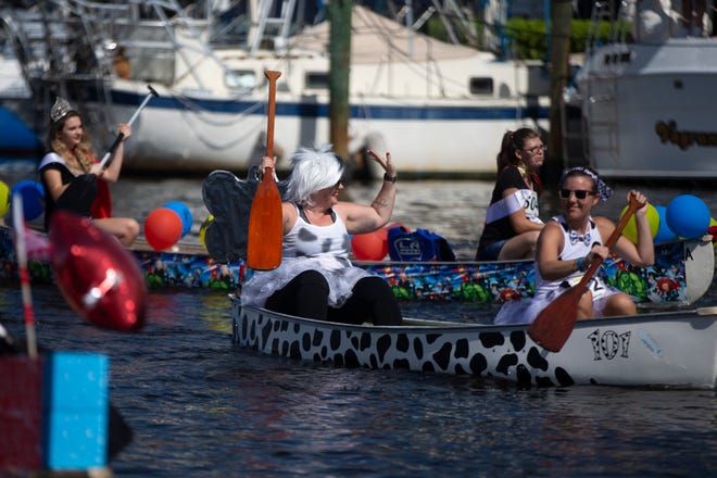 Participants in the themed canoe parade paddle along the docks, Saturday, May 11, 2019, during the 43rd annual Great Dock Canoe Race at Crayton Cove in Naples.