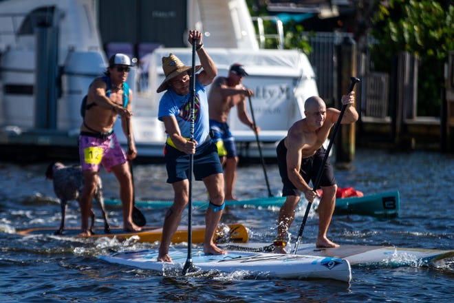 Competitors in the amateur stand up paddleboard race make their way down the race course, Saturday, May 11, 2019, during the 43rd annual Great Dock Canoe Race at Crayton Cove in Naples.