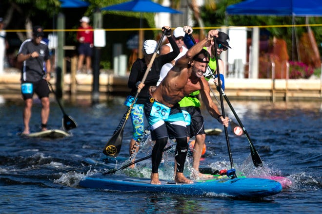 Competitors take off from the starting line in the professional stand up paddleboard race category Saturday, May 11, 2019, during the 43rd annual Great Dock Canoe Race at Crayton Cove in Naples.