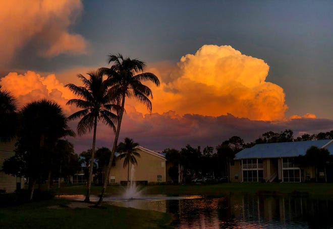 The setting sun illuminates tall clouds in North Naples on a recent evening.