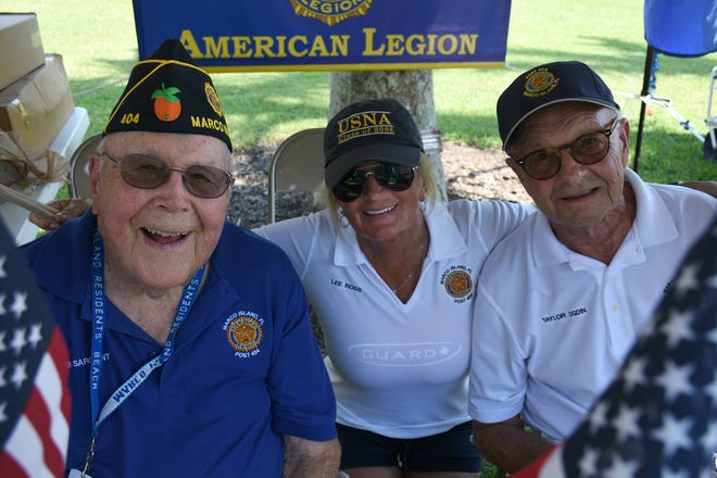 Bob Sargent, from left, Lee Ross, and Taylor Ogdin sell flags and caps for the American Legion. Marco Island's Fourth of July was a day at the beach, with activities, splashing and thousands thronging the shore for Uncle Sam's Sand Jam.