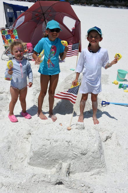 Lucy, from left, Cassie, and Kate Osenga built a sandcastle, but were more interested in their popsicles. Marco Island's Fourth of July was a day at the beach, with activities, splashing and thousands thronging the shore for Uncle Sam's Sand Jam.