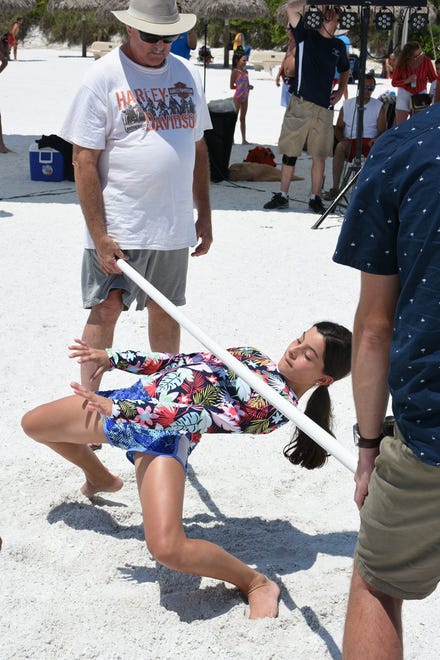 How low can you go? Eventual winner Victoria Areas, 12,  competes in the limbo contest. Marco Island's Fourth of July was a day at the beach, with activities, splashing and thousands thronging the shore for Uncle Sam's Sand Jam.