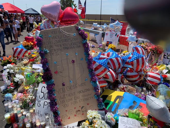 Mourners leave signs at a makeshift memorial near a Walmart in El Paso where 22 were killed and dozens more injured.