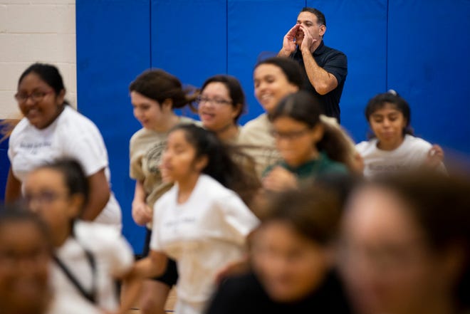 Chris Gelardi cheers on his students as they participate in a fitness test during a physical education class at Golden Gate Middle School on Thursday, Aug. 22, 2019.