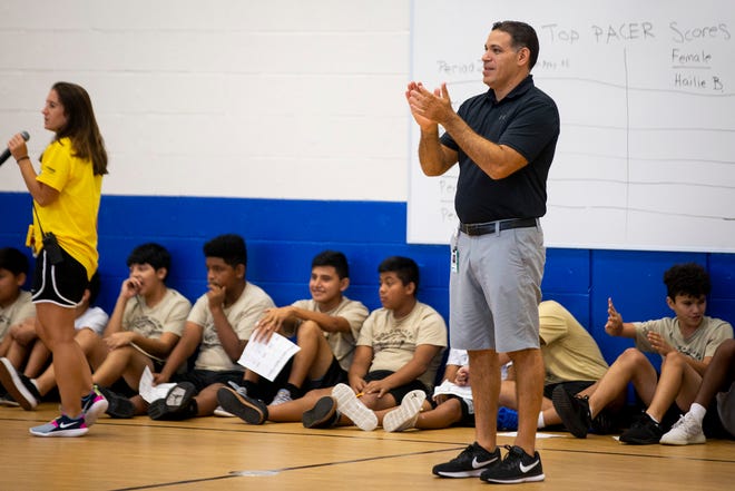 Chris Gelardi cheers on his students as they participate in a fitness test, called PACER, during a physical education class at Golden Gate Middle School on Thursday, Aug. 22, 2019.