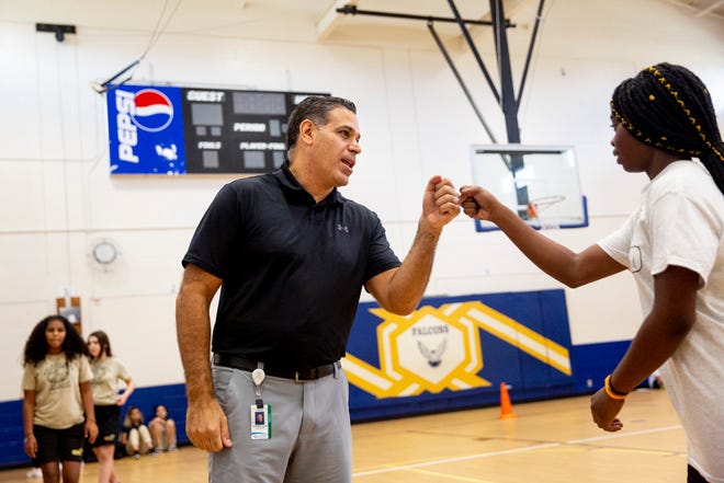 Chris Gelardi fist bumps Edwine Herard after she completes her fitness test during a physical education class at Golden Gate Middle School on Thursday, Aug. 22, 2019. Gelardi was a police officer in New York for a decade before moving to Florida with his family and starting a career in teaching.
