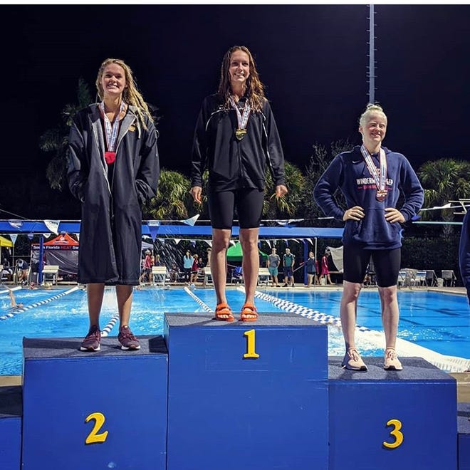 Marco Island resident and St. John Neumann senior Maddy Burt stands atop the podium after winning the Class 1A state championship in the 100-yard butterfly. Burt's gold was her sixth medal in four state appearances and the first-ever gold by a St. John Neumann swimmer.
