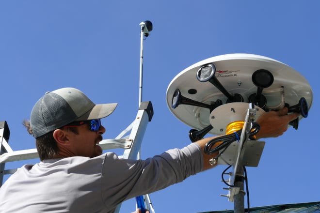 Alex Gonzalez from Thor Guard installs a lighting warning system at Caxambas Park and Boat Ramp in Marco Island on Feb. 4, 2020.