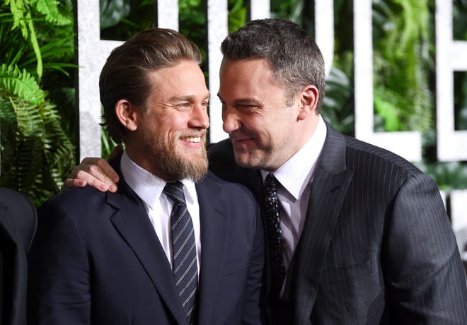 He shares a laugh with Charlie Hunnam at the world premiere of " Triple Frontier " on Mar. 3, 2019.