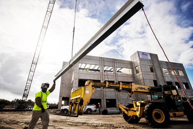 Jean Paul Fenelon, an employee of Suncoast Industries steadies the last steel beam as it is hoisted to the top of the new FineMark Bank headquarters in south Fort Myers. Read the story: http://bit.ly/39rnAyo
