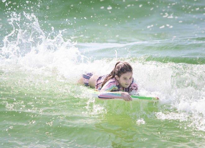Finley West, 12, boogie boards at Casino Beach in Pensacola on Thursday, March 19, 2020.