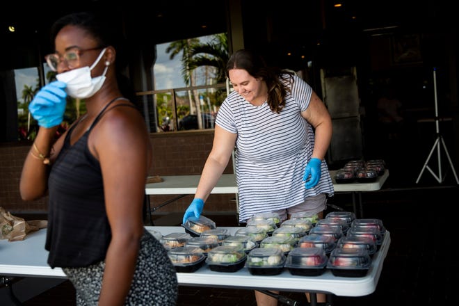 Rachel Meltzer, left, and Caroline Farrell, right, hand out meals at Broadway Palm Dinner Theatre in Fort Myers on Saturday, March 21, 2020.
