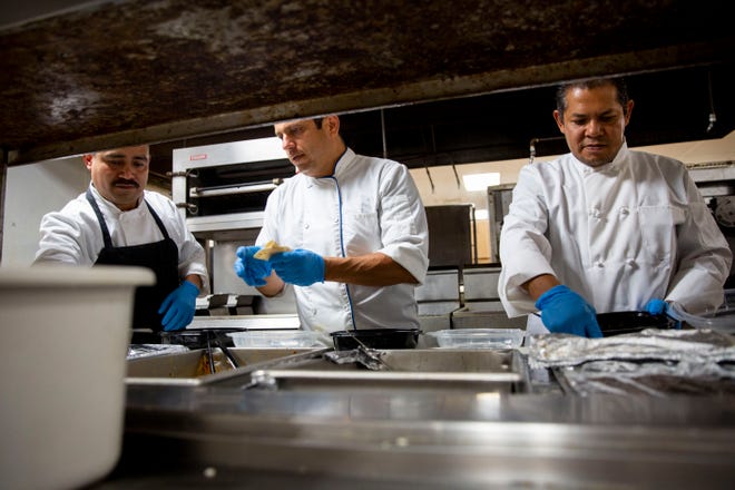 From left to right, Moses Diaz, Marbin Avilez and Miguel Angel Guzman prepare meals at Broadway Palm Dinner Theatre in Fort Myers on Saturday, March 21, 2020.