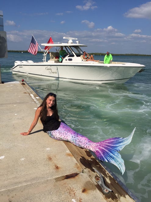Dr. Rick Siegel aboard "Cavity Search" pulls away after donating a $20 tip to the little mermaid. Summer Joy Hill, 16, has been donning her mermaid tail and waving to passing boats to cheer people up during the coronavirus pandemic.