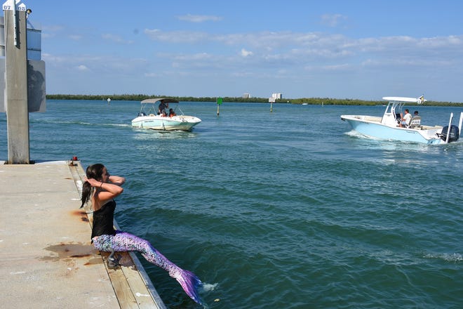 Summer greets passing boaters. Summer Joy Hill, 16, has been donning her mermaid tail and waving to passing boats to cheer people up during the coronavirus pandemic.